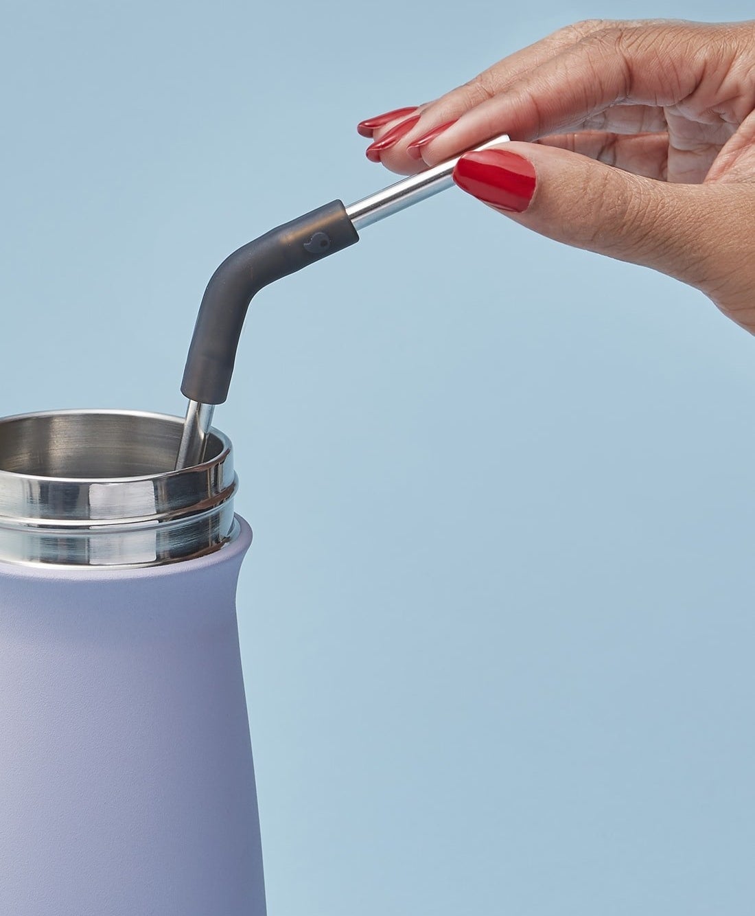 manicured hand holds black reusable straw in S&#x27;well tumbler