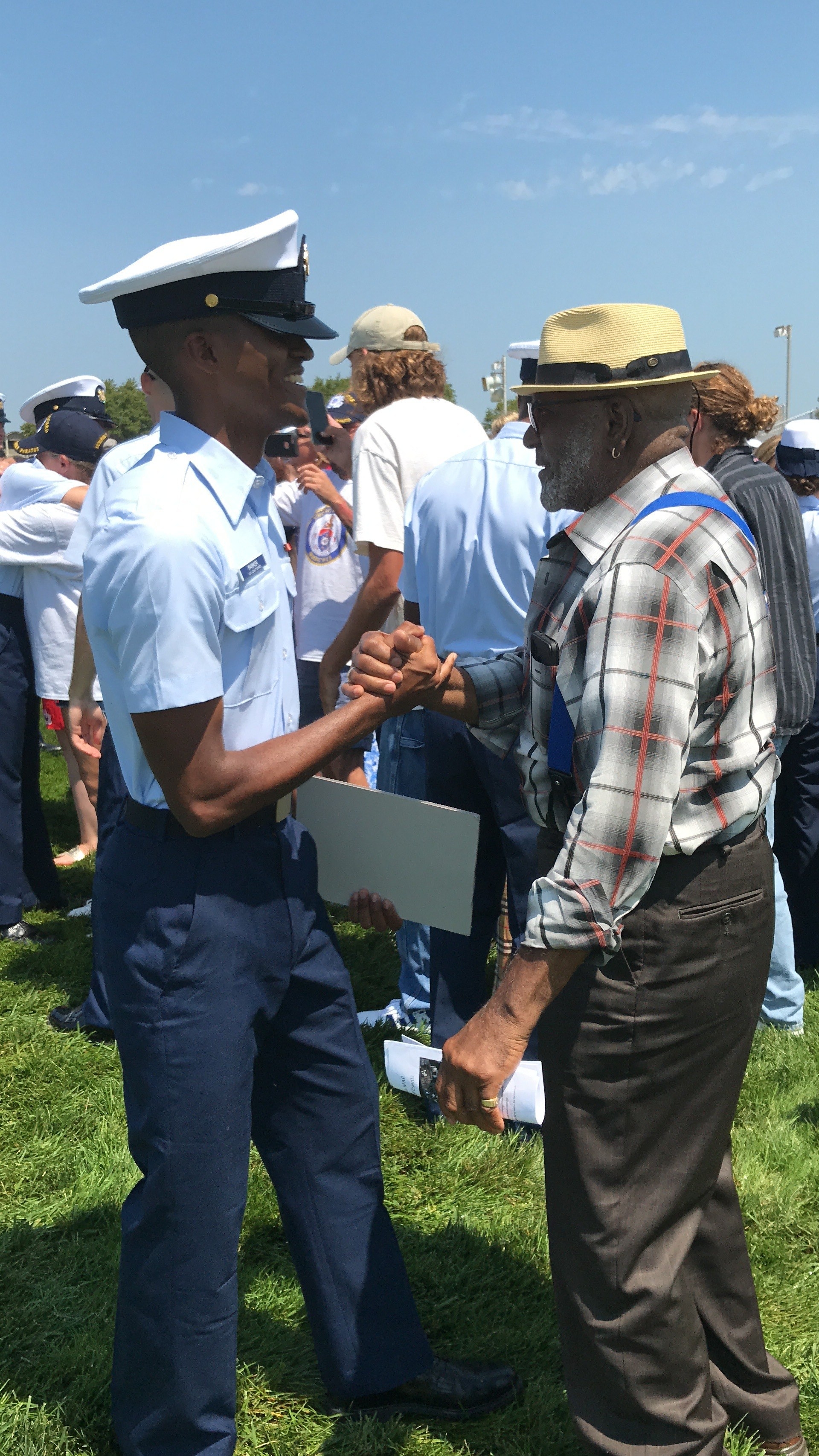 FA Tyrique Parker, dressed in formal military clothes, shakes hands with an older relative