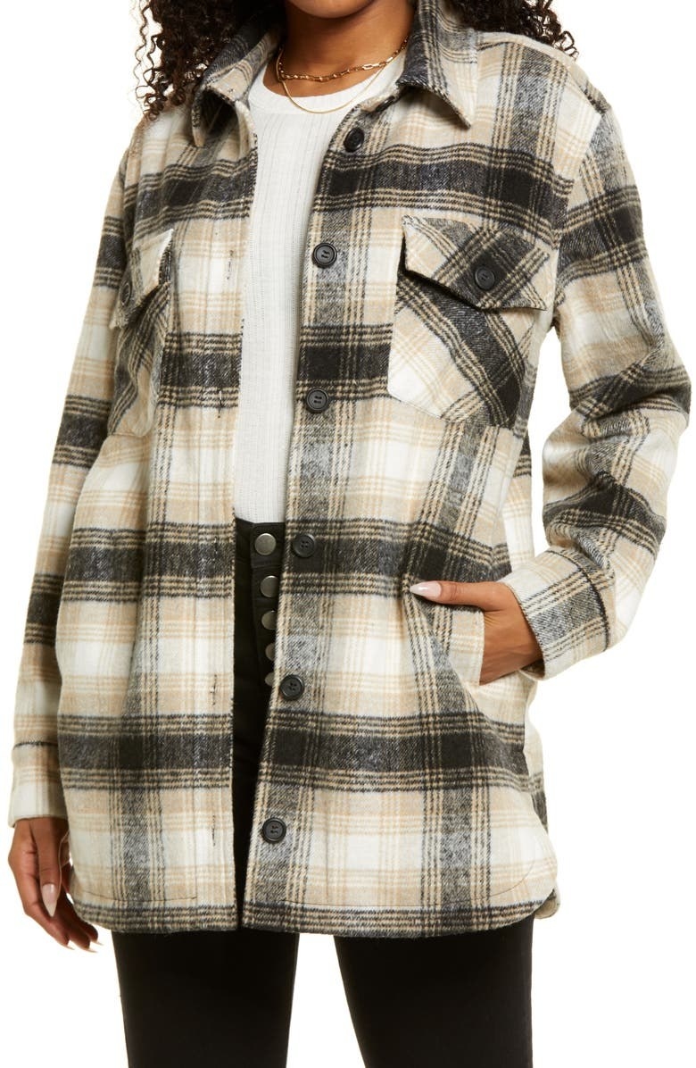 model wearing the black and tan plaid button-down shirt jacket