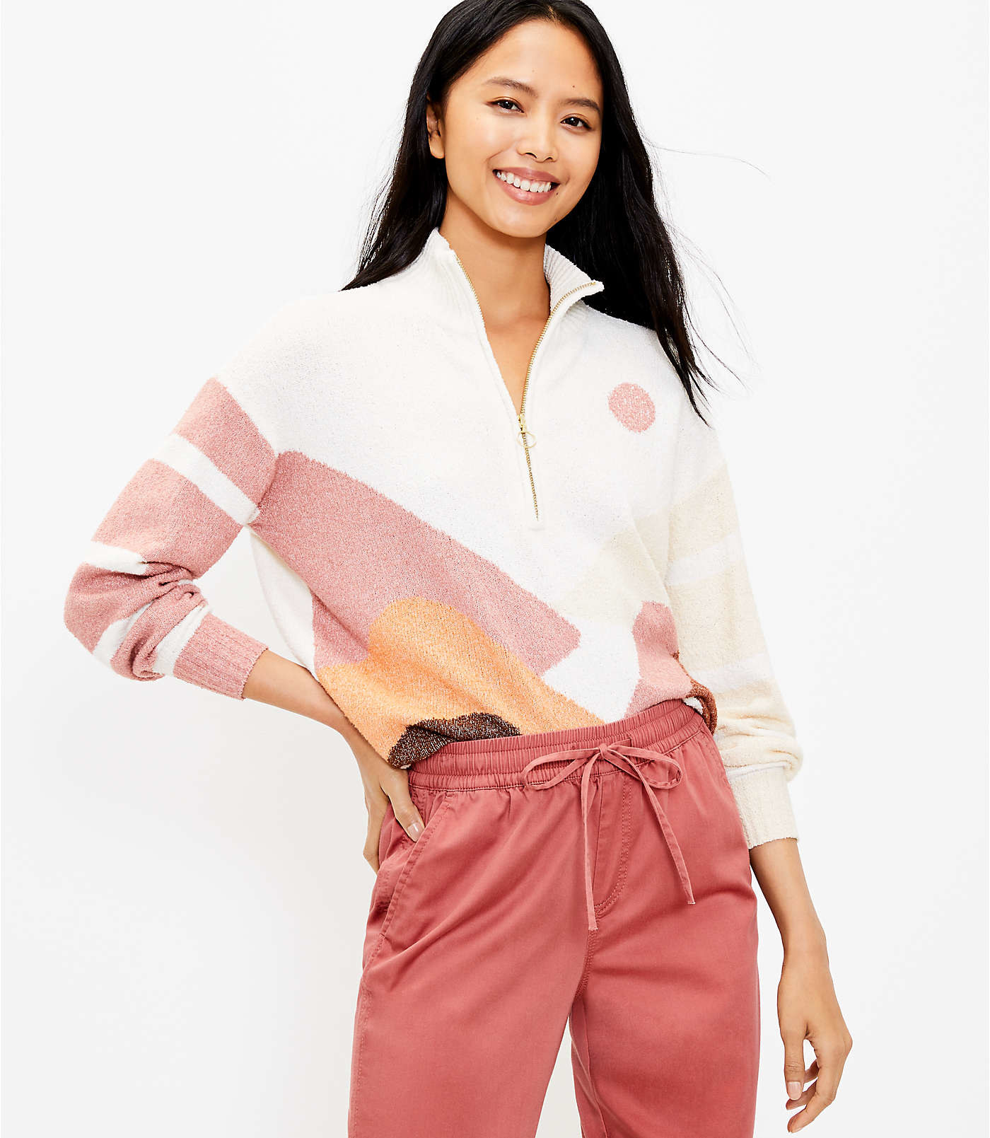 model wearing the quarter-zip sweater in white, pink, and orange