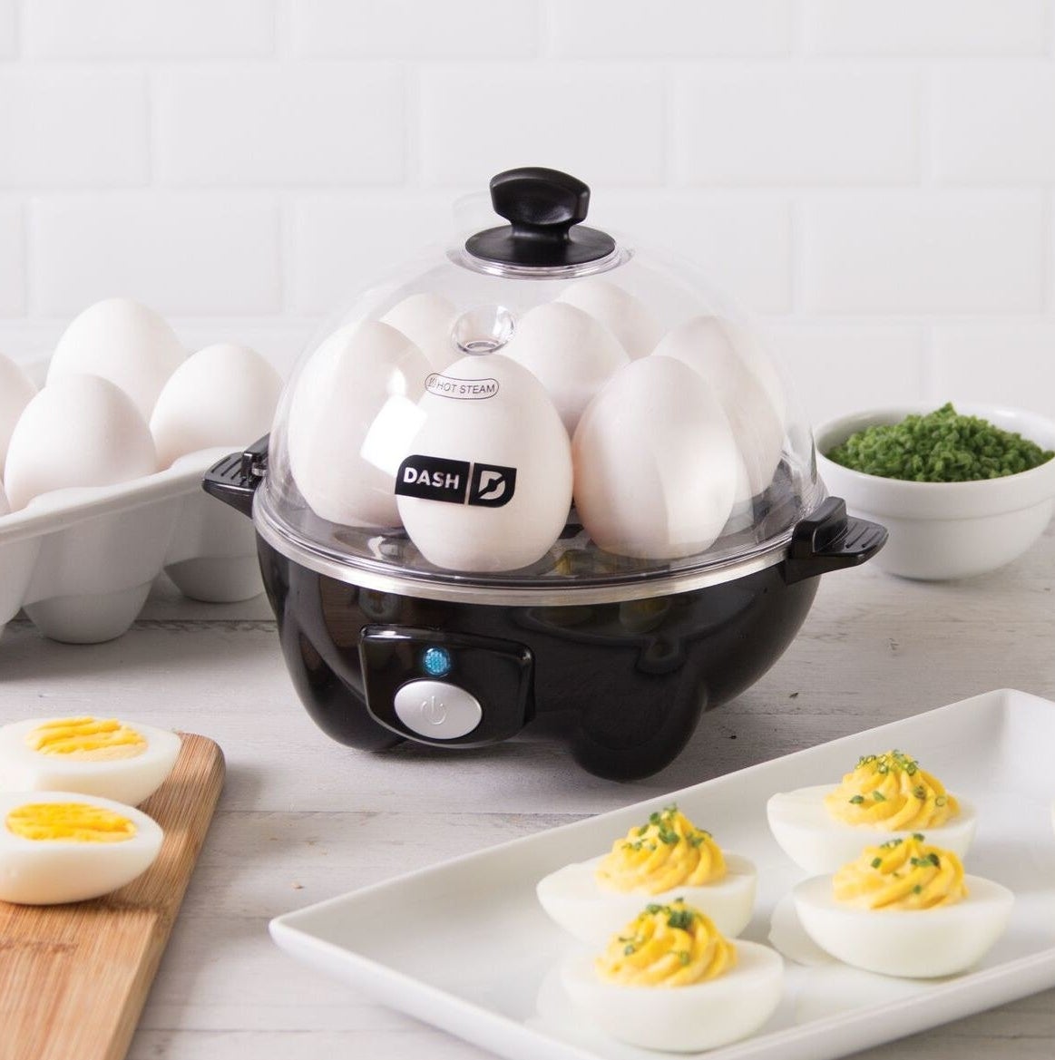 black rapid egg cooker with eggs inside next to hard boiled and deviled eggs