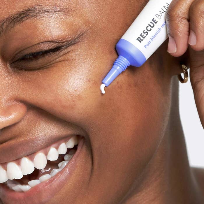 model applying the cream to their cheek