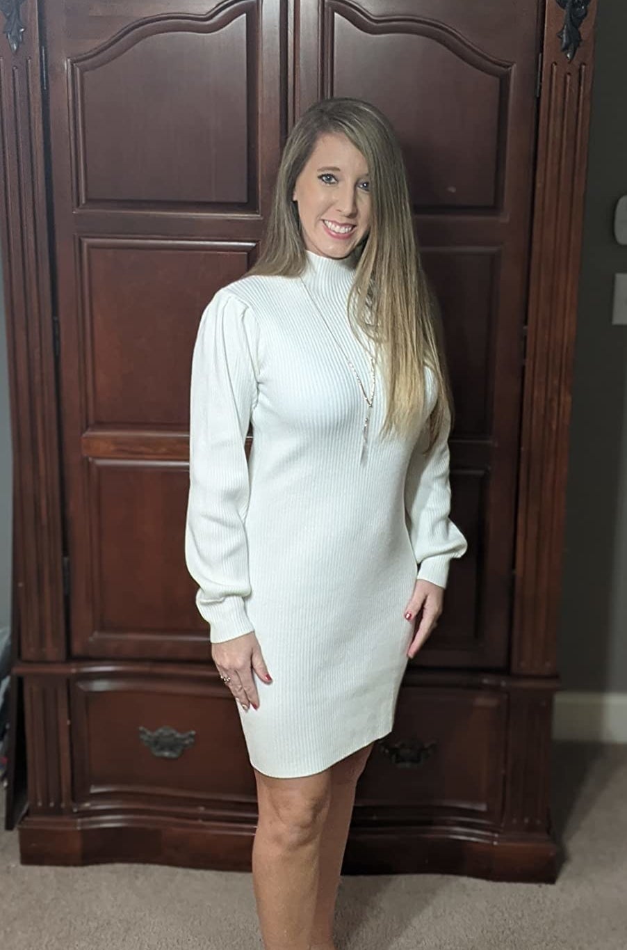 Reviewer wearing the white long-sleeve knit turtleneck sweater dress
