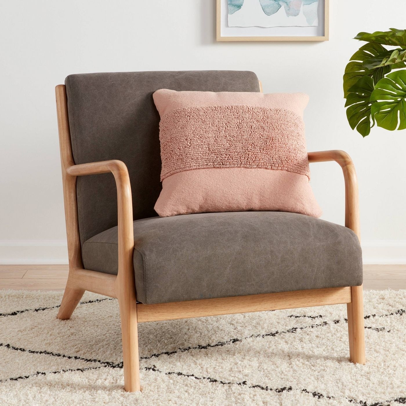 blush colored throw pillow on an arm chair