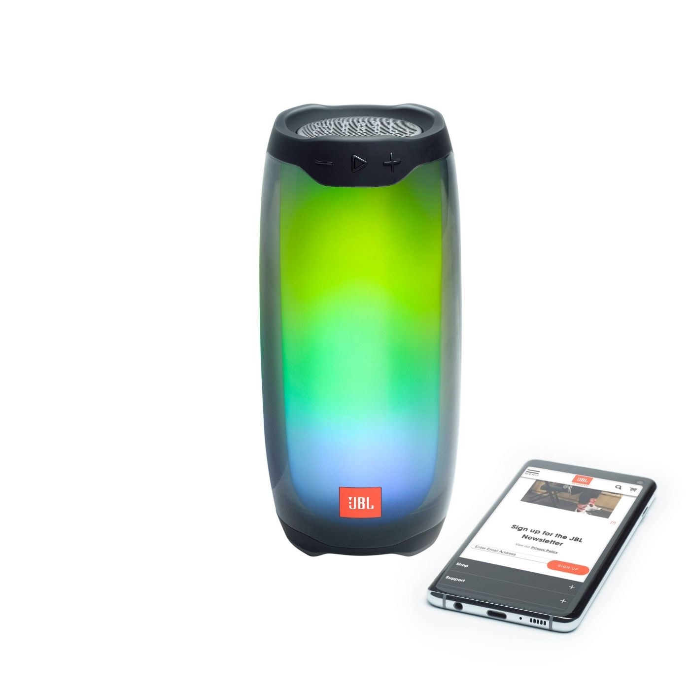 small JBL speaker lit up next to a cell phone