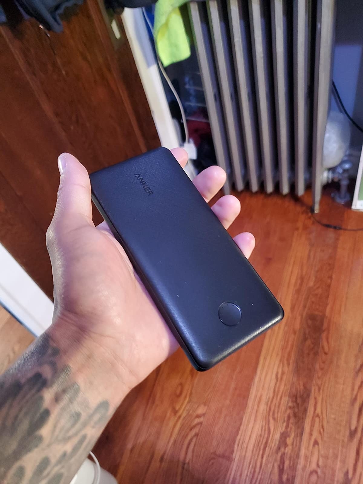 reviewer holding the black power bank, which is about the size of an iPhone