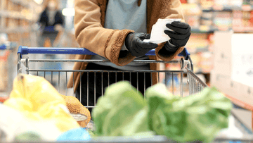 woman checking grocery list in supermarket