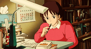 A young girl studying at a table filled with books