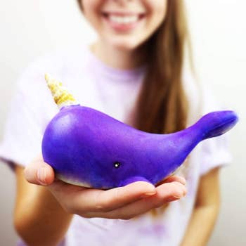 A model holding a purple narwhal squishie