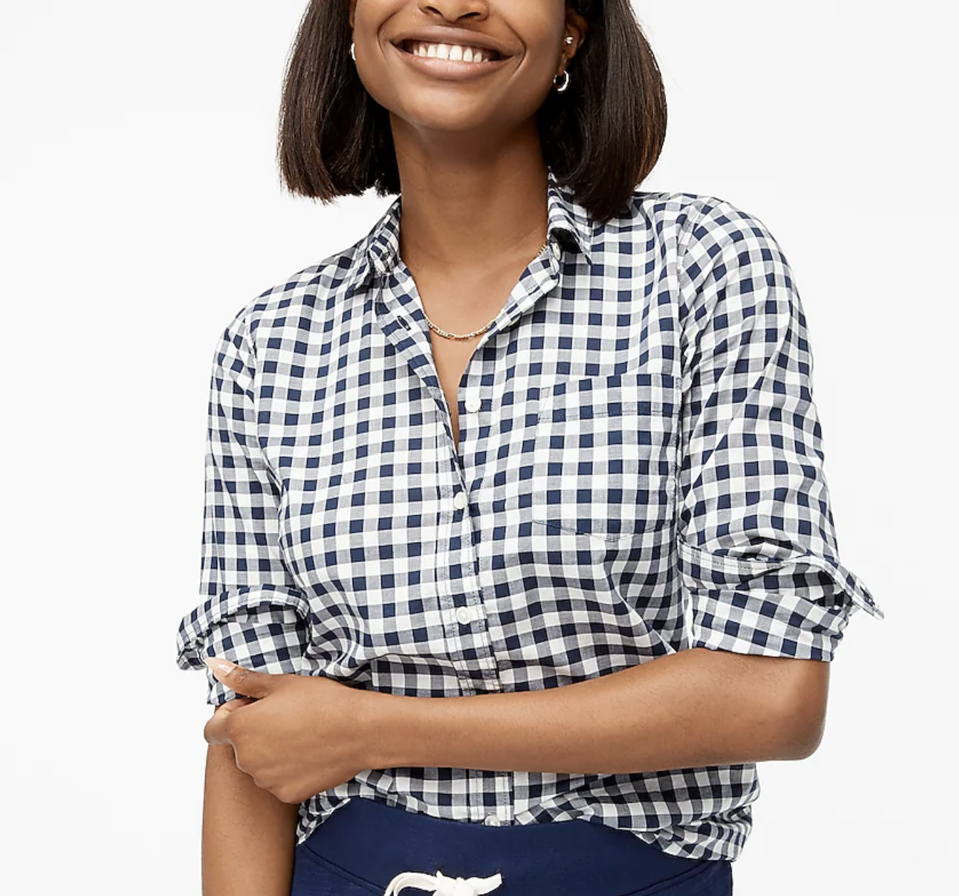 Model is wearing a black and white gingham print button down top