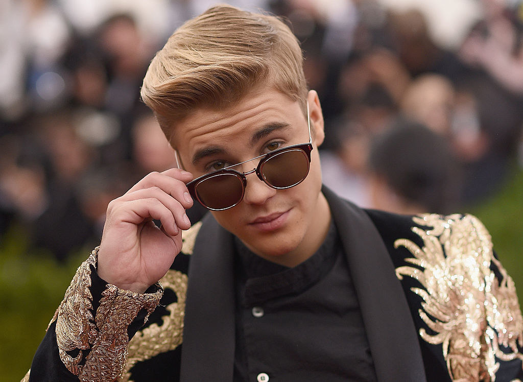 Justin Bieber peeks over his sunglasses while on the Met Gala red carpet