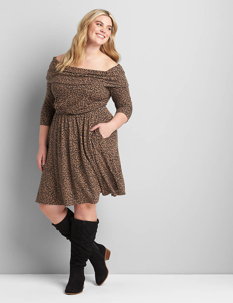 Model is wearing a leopard print off the shoulder dress with black calf-length boots