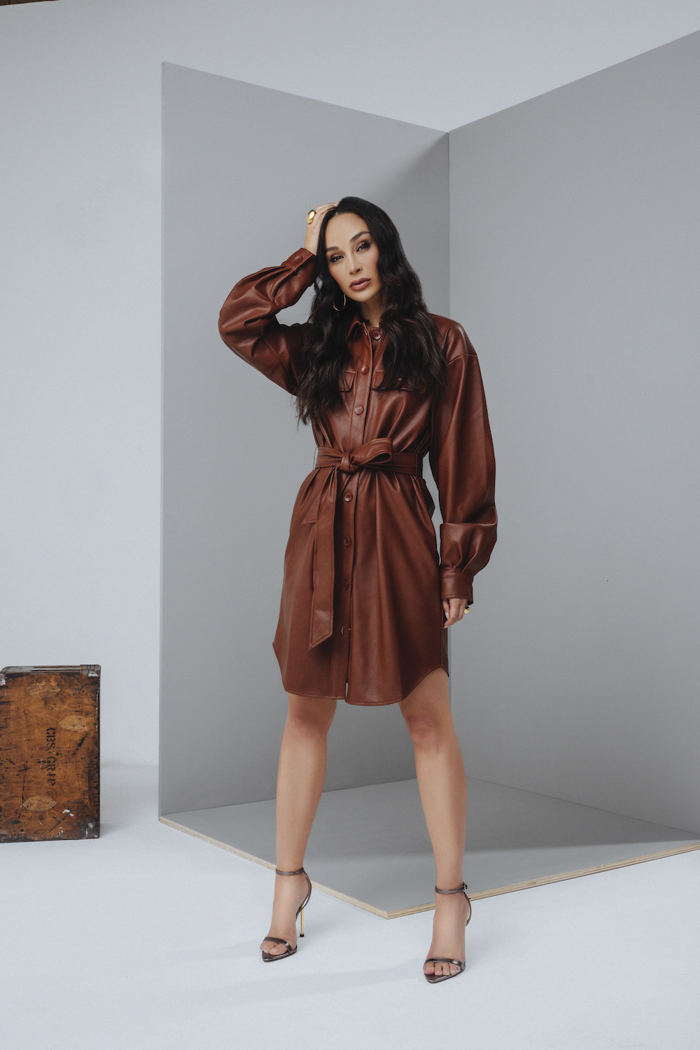 model wearing the knee-length button-down shirt dress in dark brown with tie around the waist