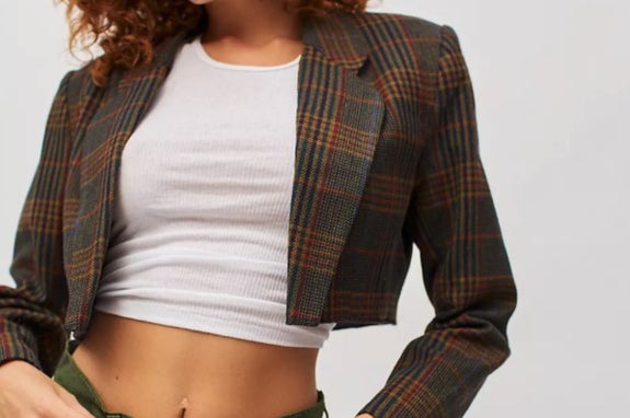model wearing a cropped blazer with a crop top and jeans