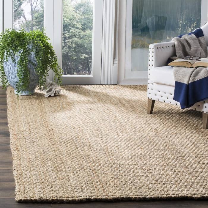 Jute area rug shown with armchair and plant in the corner.