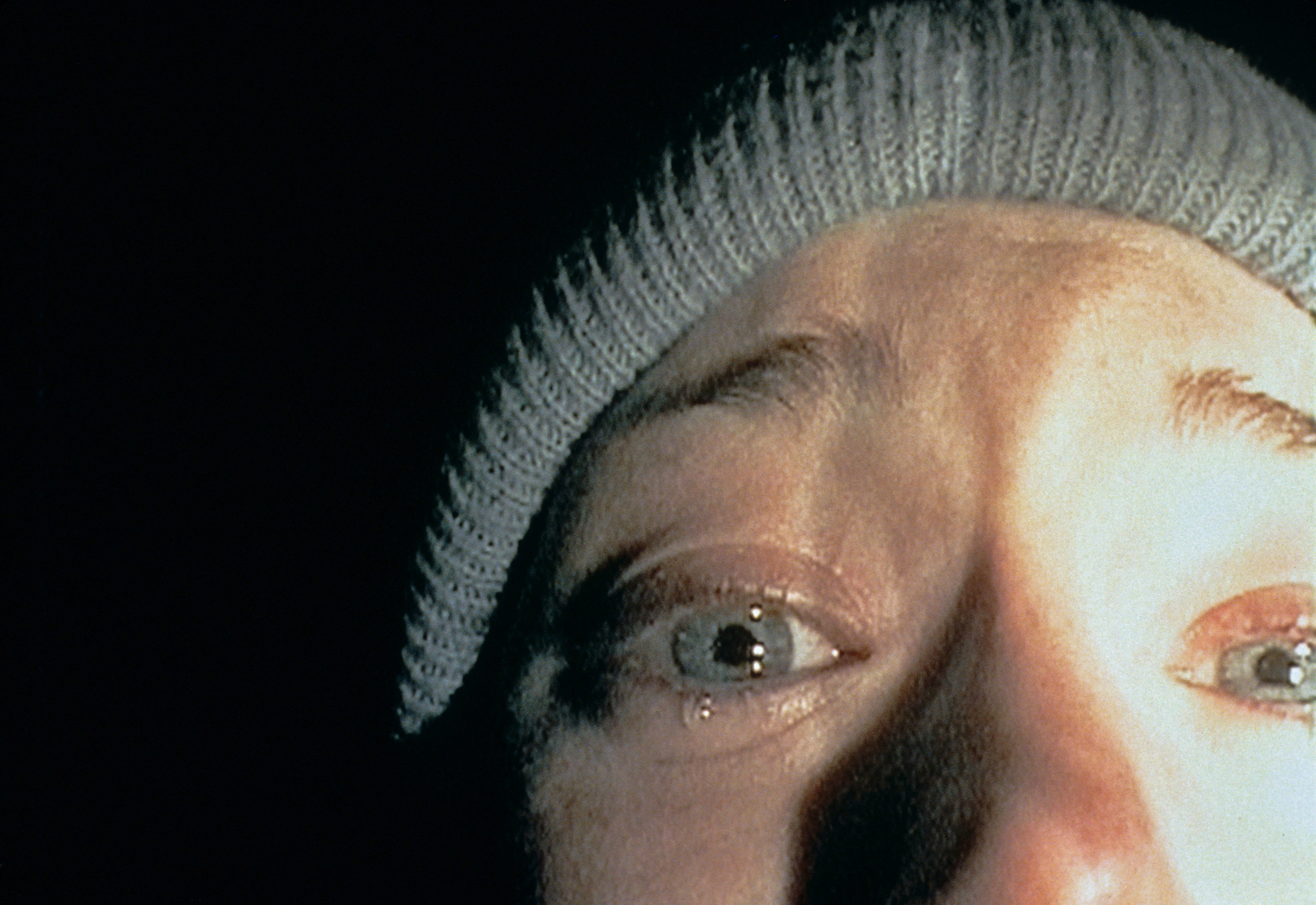 Flashlight-illuminated woman cries in the darkness