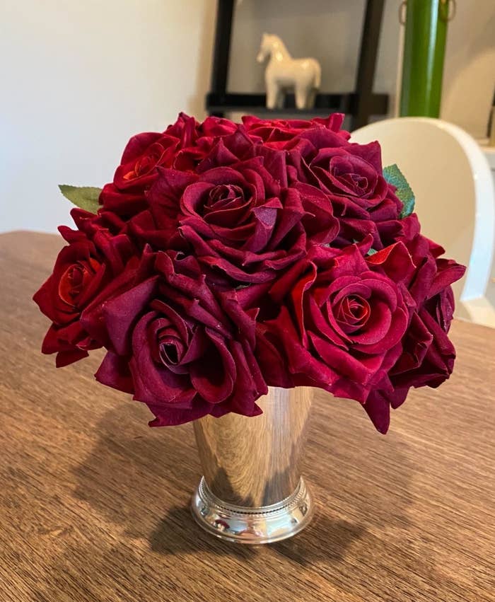 Reviewer&#x27;s bouquet of faux red roses are arranged in a silver vase