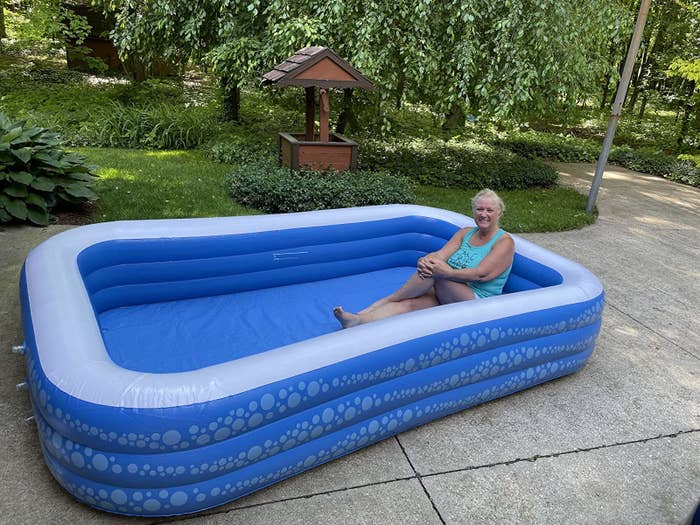 reviewer sitting in the pool showing how large and roomy it is