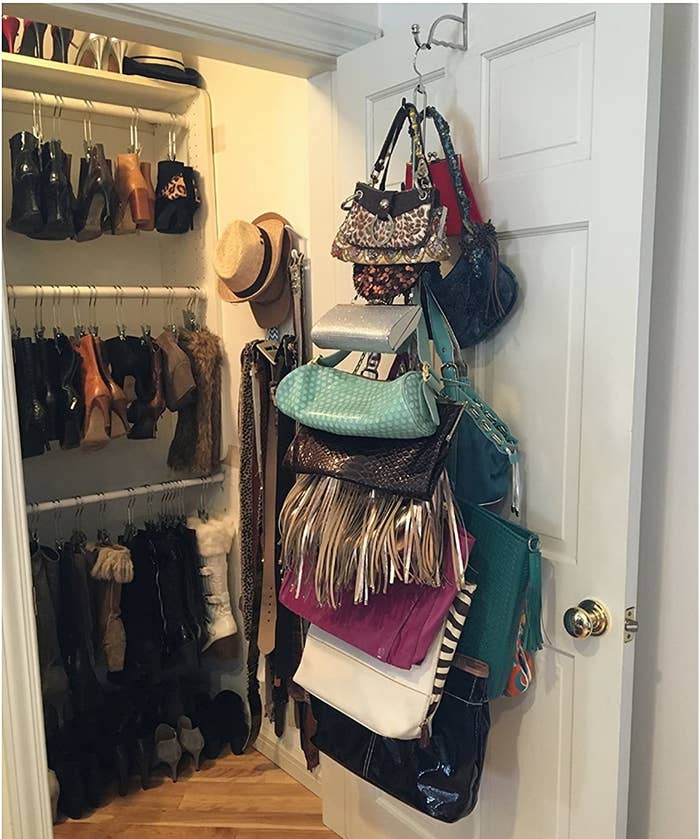 the hanger holding around 15 purses from the back of a closet door