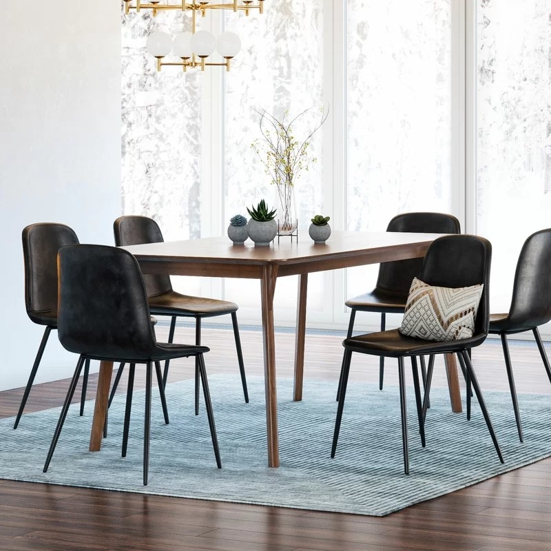 The black faux leather chairs around a rectangular table in a dining room