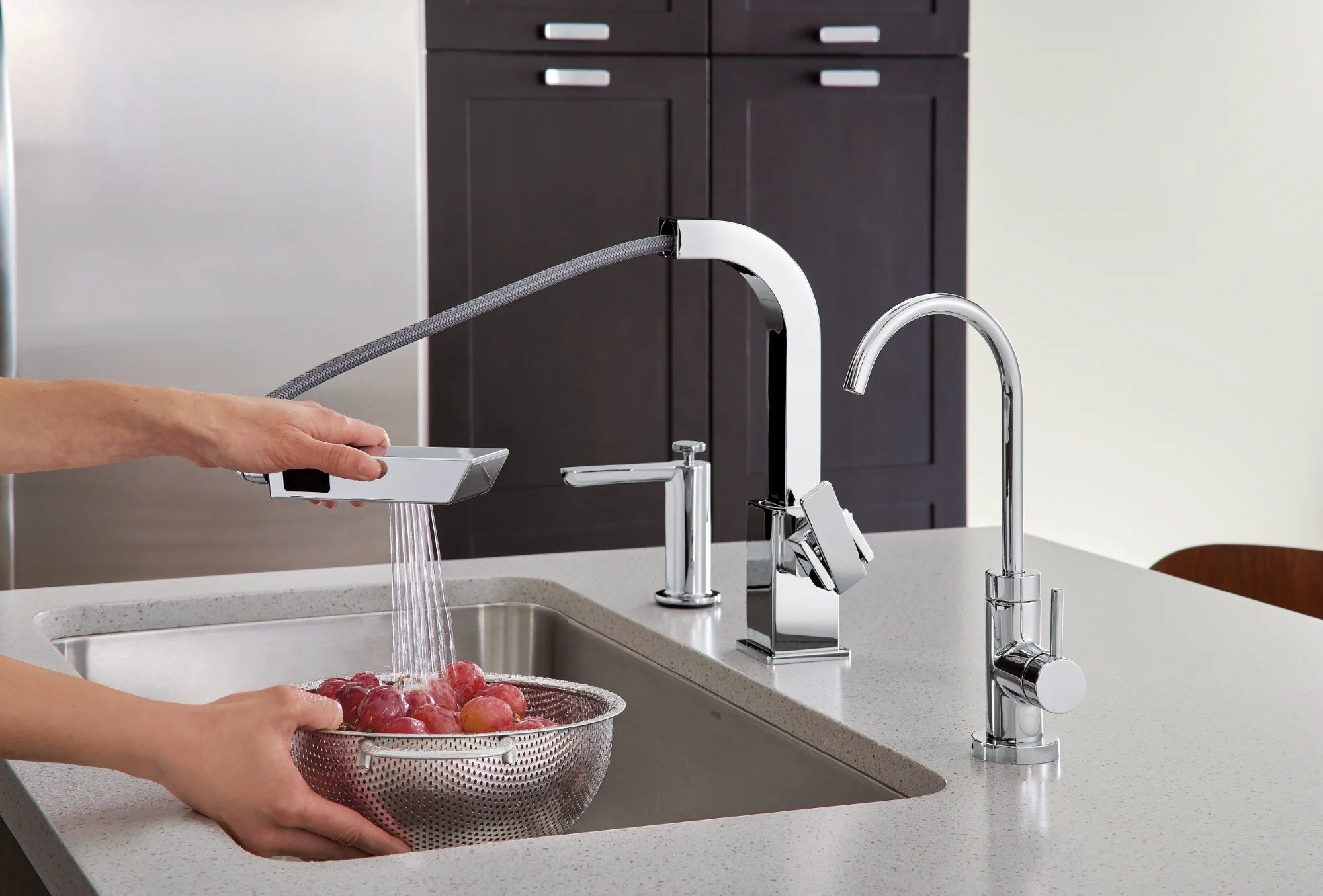 The soap dispenser in a kitchen next to a matching faucet