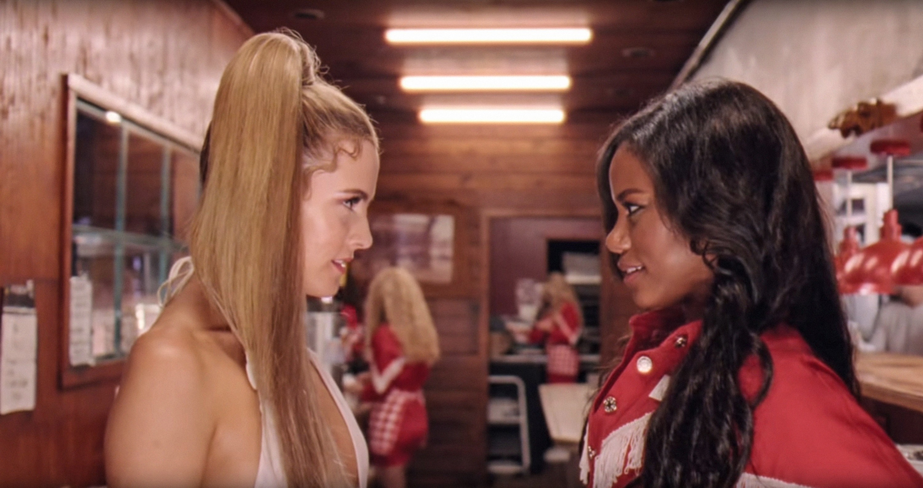 Riley Keough and Taylour Paige look at each other