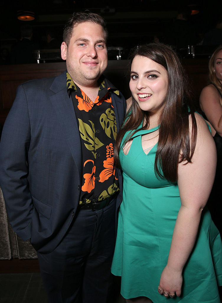 Jonah Hill and Beanie Feldstein are dressed up and pose for a smile at the premiere