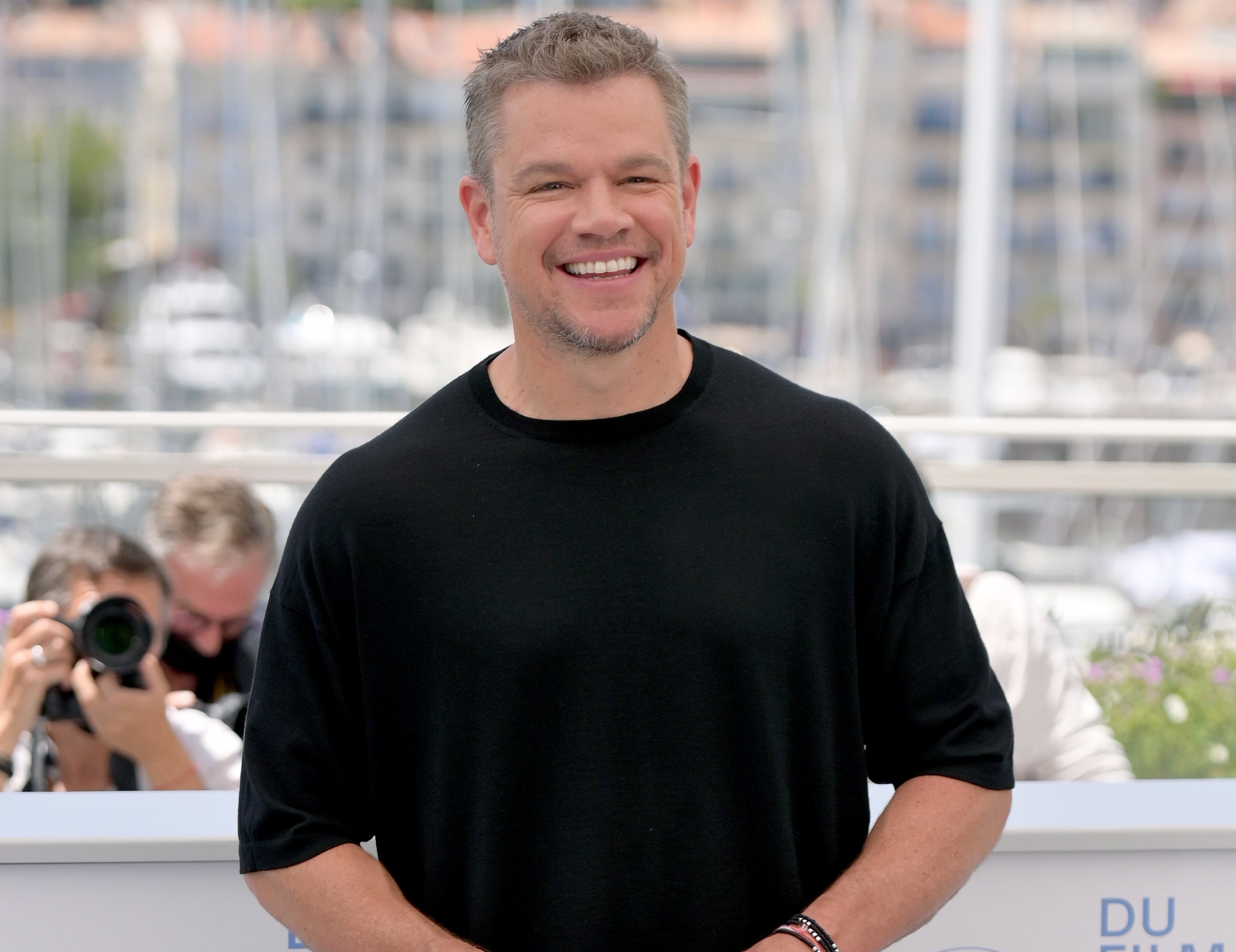 Matt laughs while wearing a black t-shirt outside