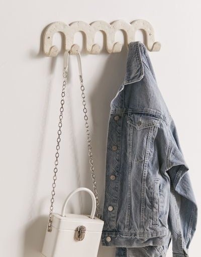 The hook set mounted on a wall holding a jacket and a bag