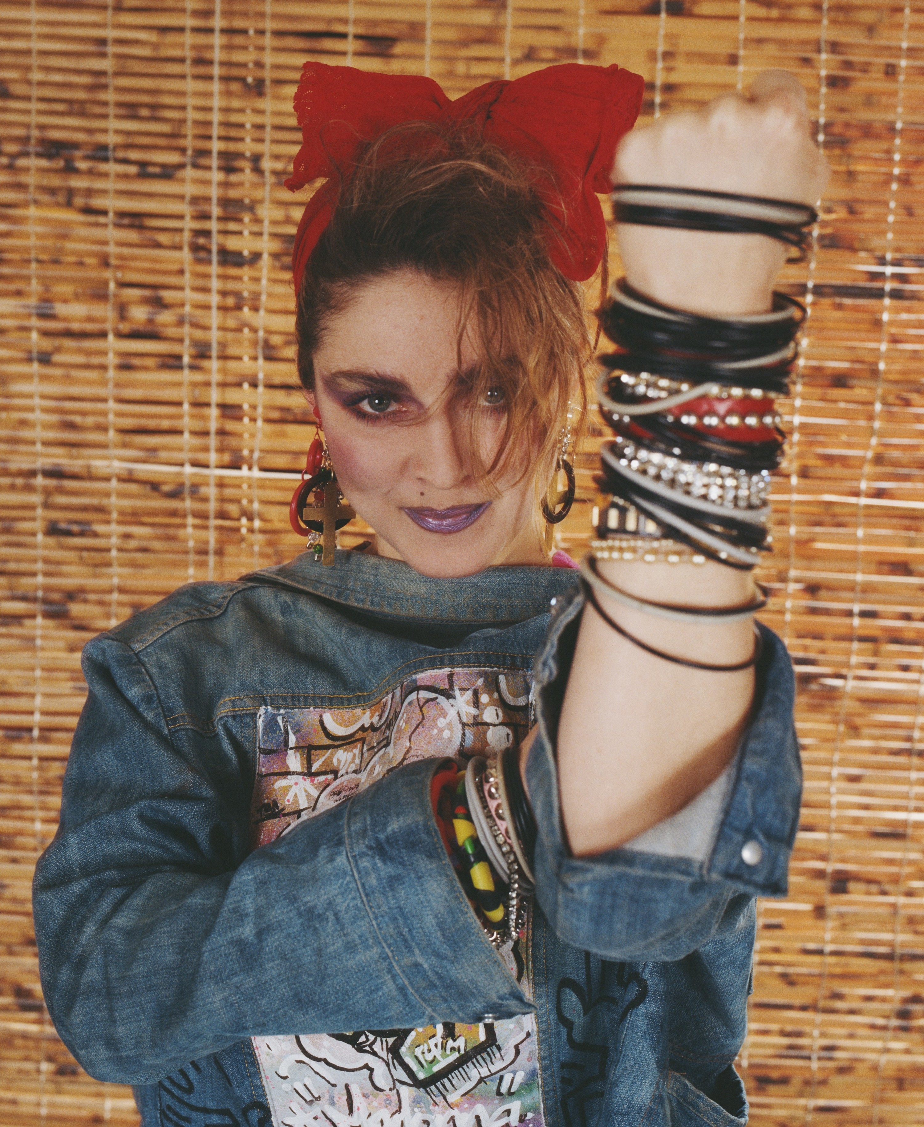 Photo of Madonna in a bright pink/purple lip and loads of bracelets