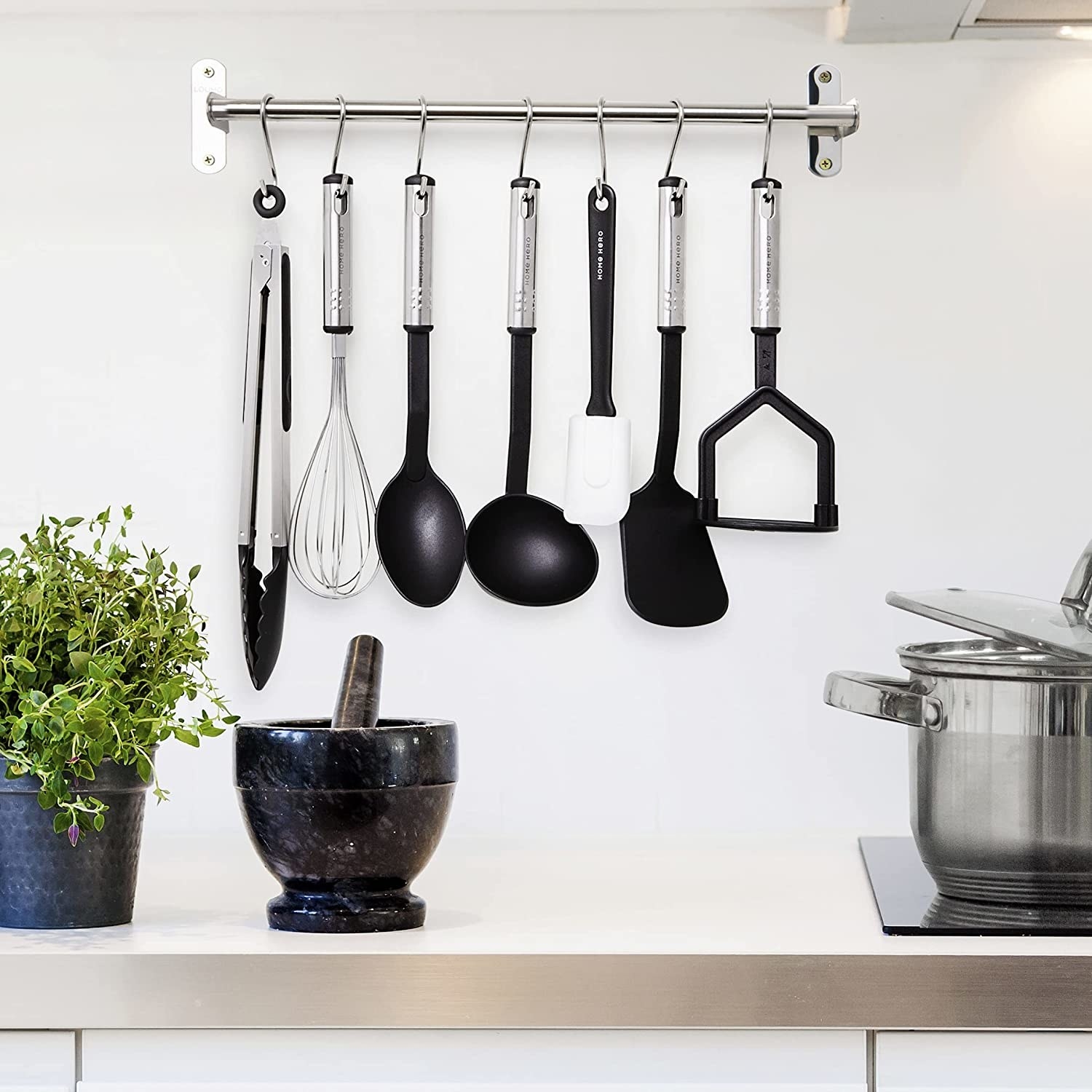 Amazon. kitchen utensils hanging from a rack above a countertop. 