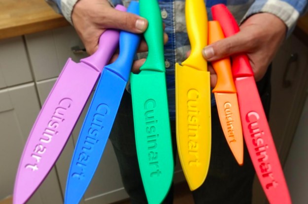 a reviewer holding the knife set with the covers on the knives in their hands