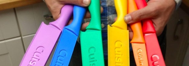 a reviewer holding the knife set with the covers on the knives in their hands