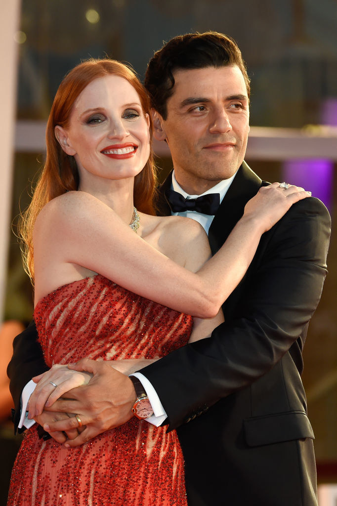 Jessica Chastain (L) and Oscar Isaac holding each other on the red carpet