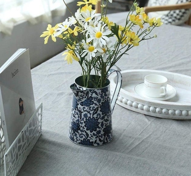 the blue rustic pitcher holding a bouquet of flowers