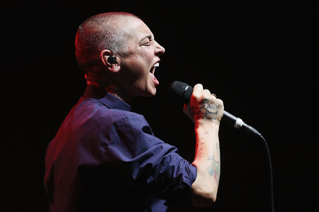 Sinead O&#x27;Connor performing on stage, singing into the microphone