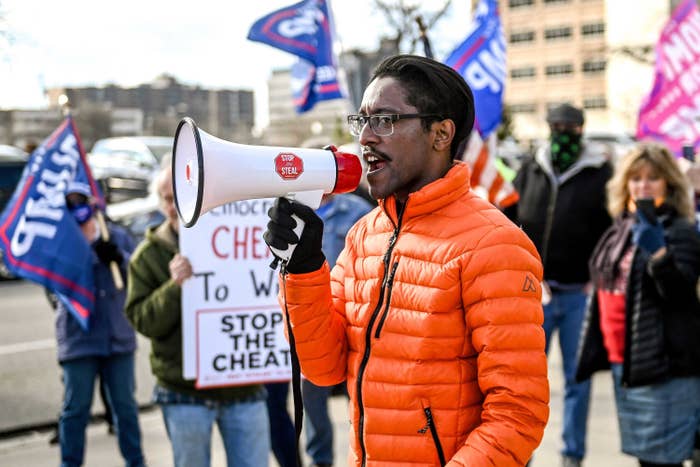 Ali Alexander speaking into a megaphone in front of other demonstrators