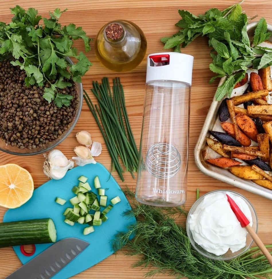 The salad dressing shaker surrounded by ingredients