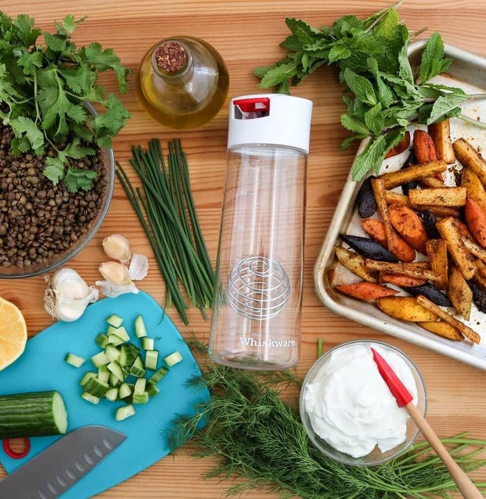 The salad dressing shaker surrounded by ingredients