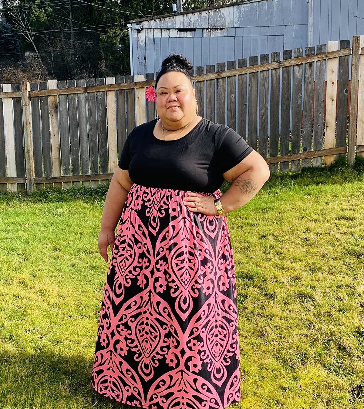 reviewer wearing the dress with black top and pink patterned bottom