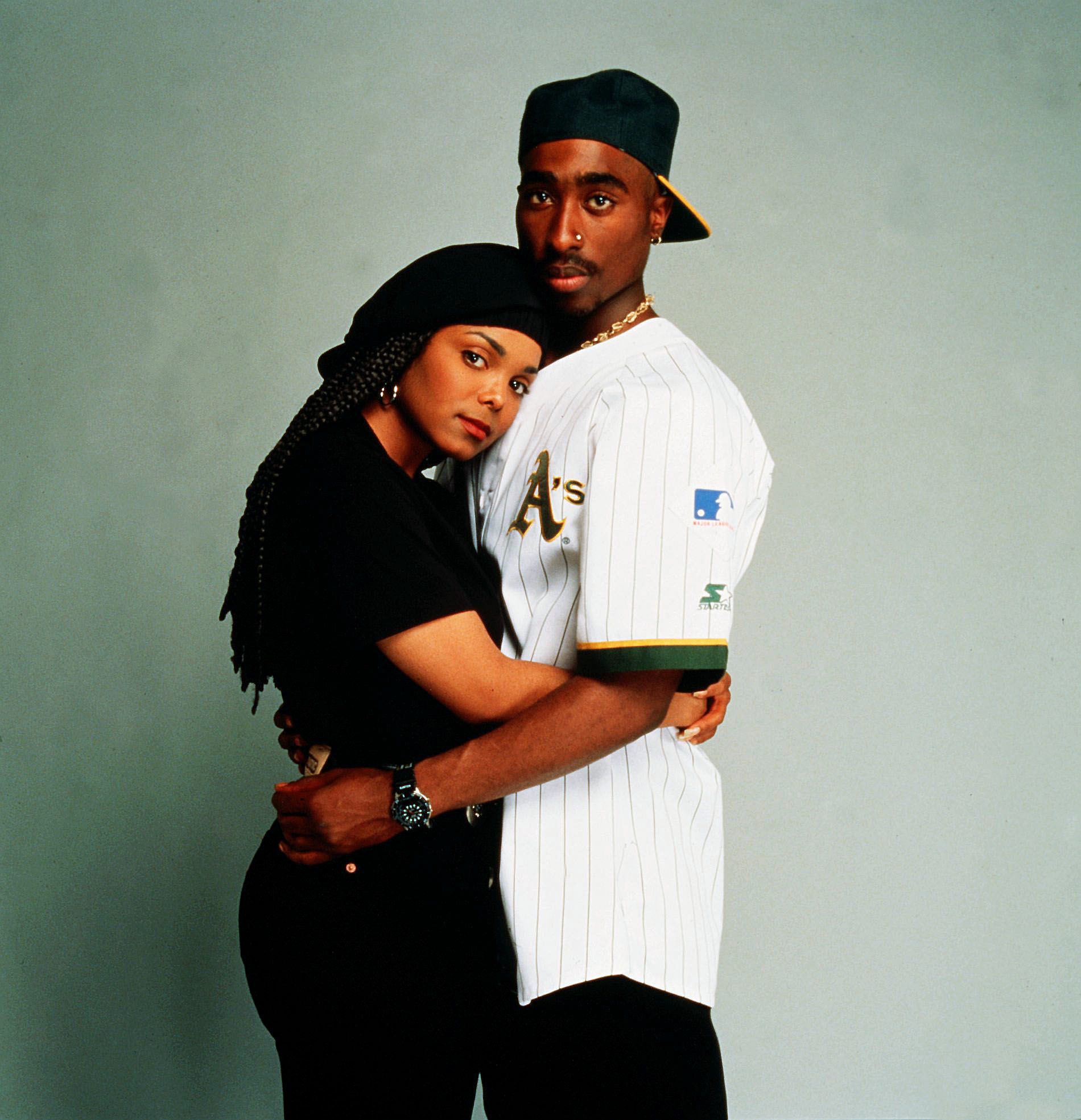 Tupac, wearing an Oakland A&#x27;s jersey, holds Janet Jackson in a photo studio