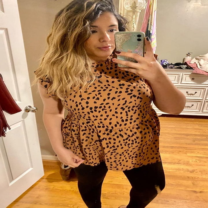 pregnant reviewer wearing light brown and black leopard sleeveless top with ruffle detail