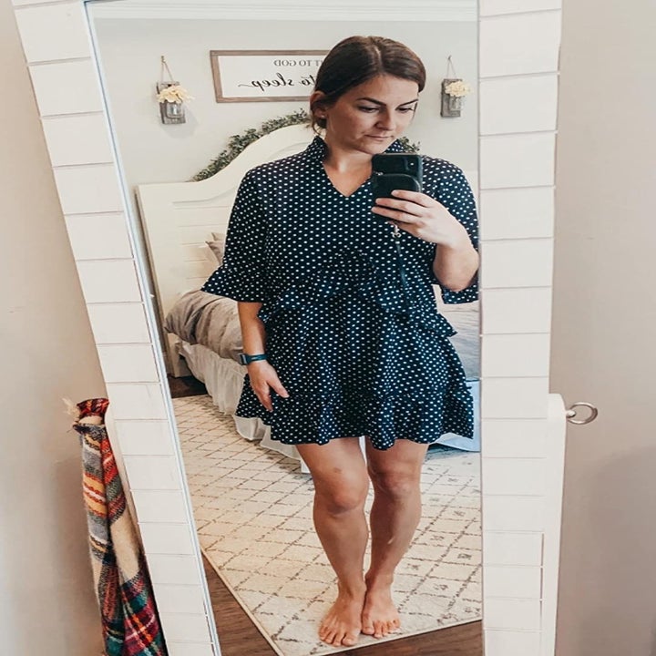reviewer wearing the dress in black with white polka dots