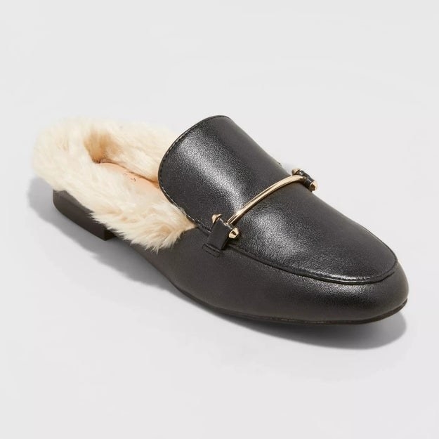 Black mule with gold accent, off-white fur around the back of the shoe