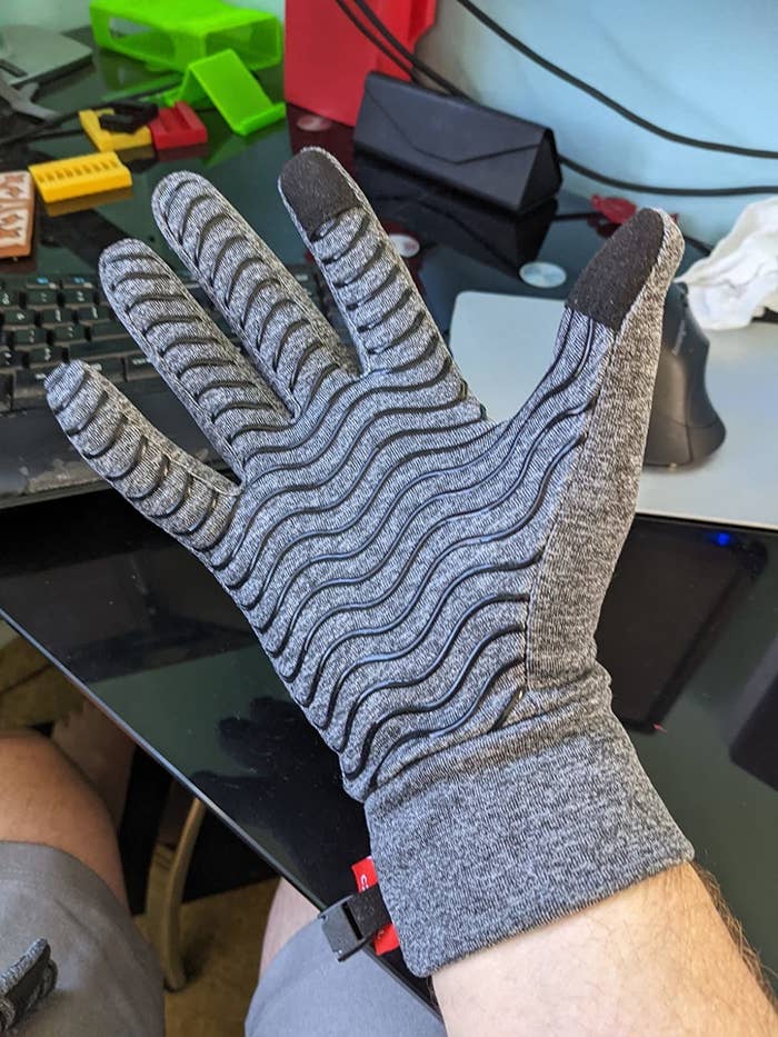 a reviewer&#x27;s hand with the gray touchscreen glove on