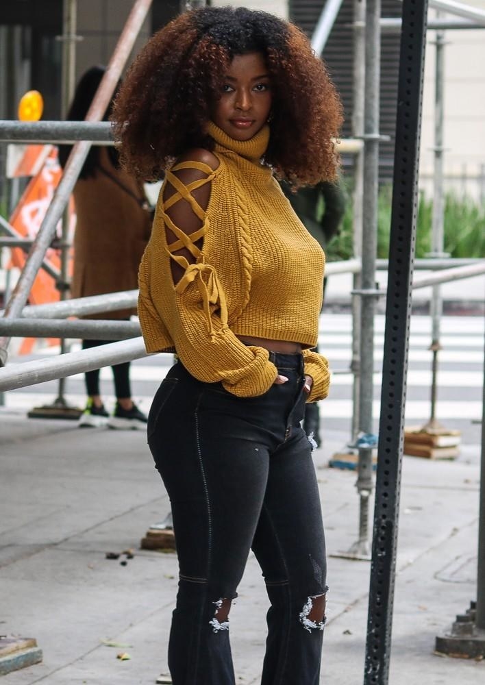 model wearing the mustard yellow sweater with black jeans
