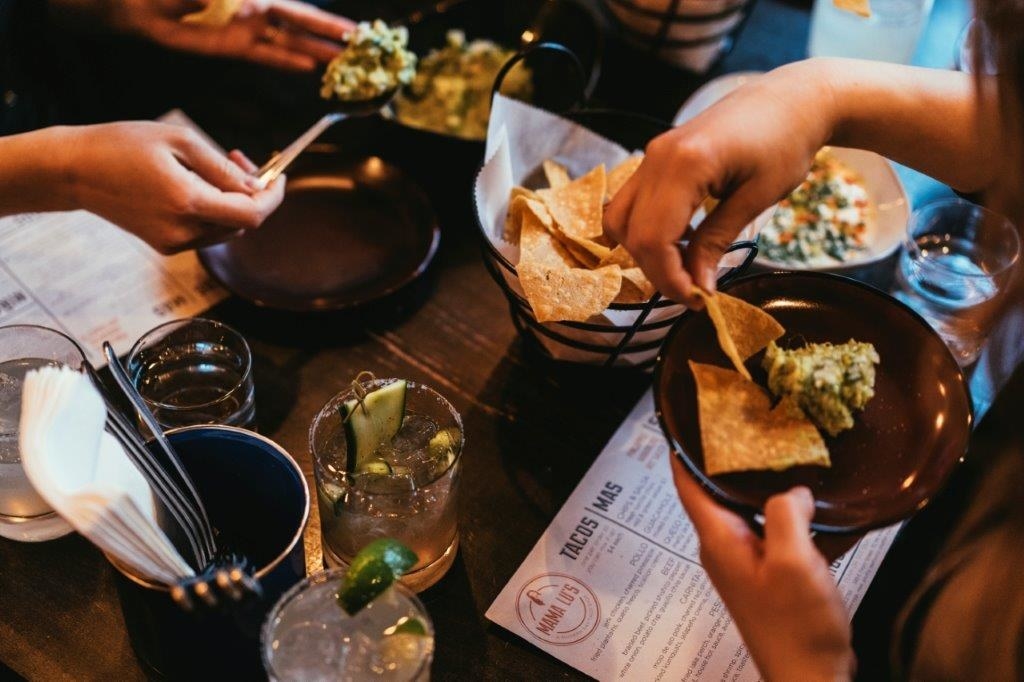 A table with chips and guacamole.