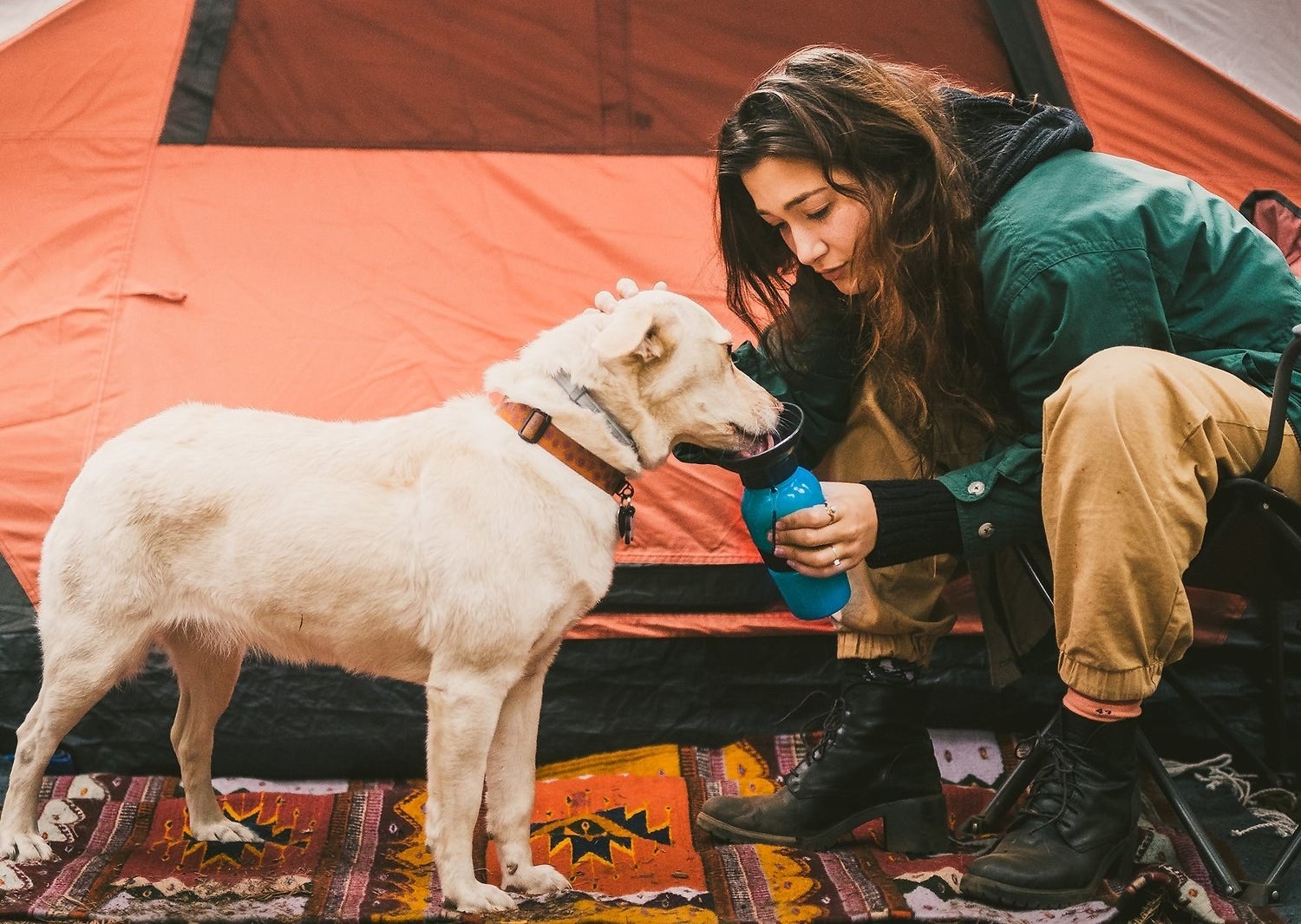 Someone giving their dog water with the water bottle/bowl combination