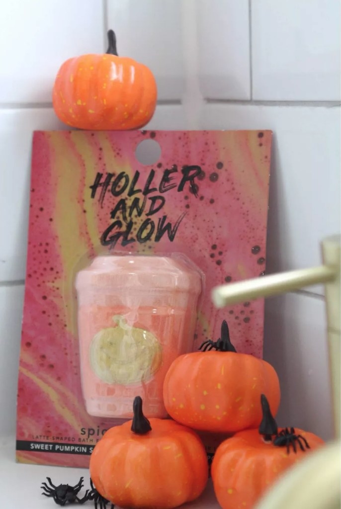 A pumpkin spice latte bath bomb next to a several mini decorative pumpkins