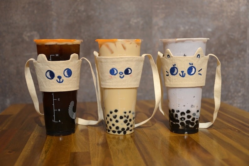the canvas cupholders with straps and cute embroidered faces